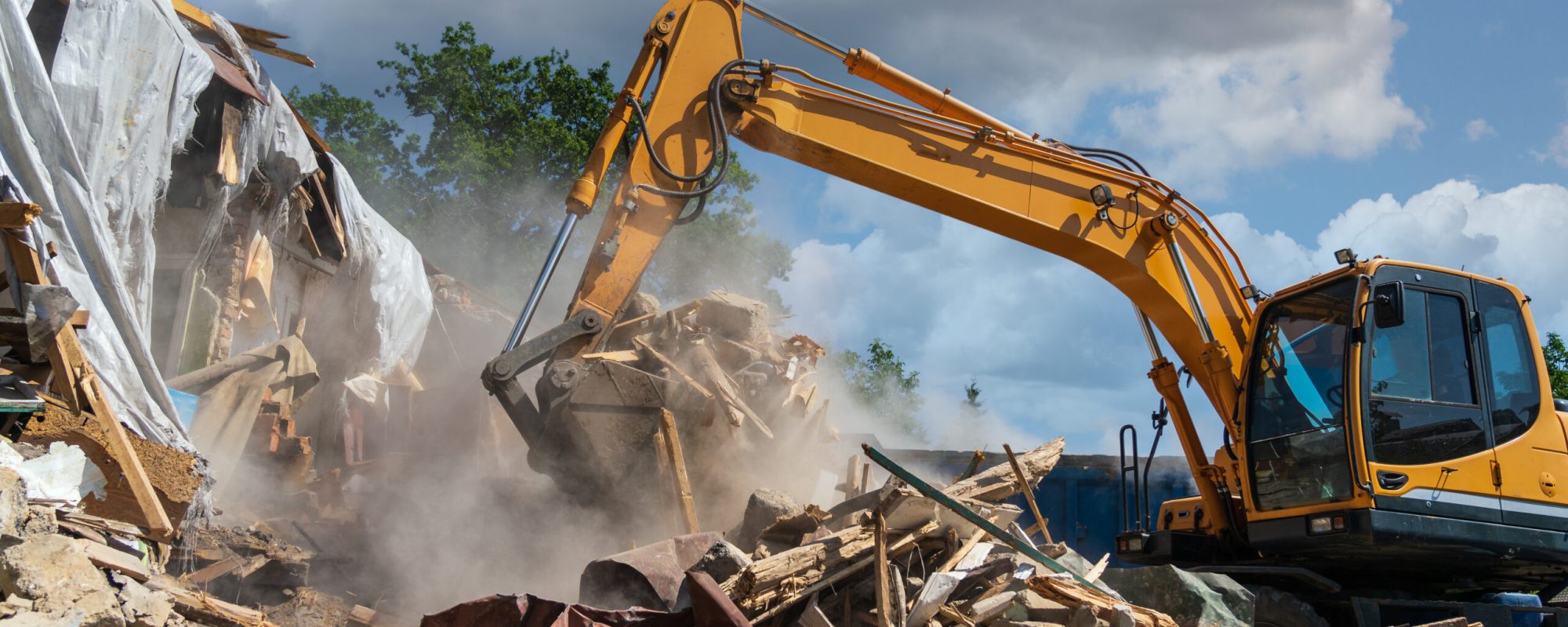 Process of demolition of old building dismantling. Excavator breaking house. Destruction of dilapidated housing for new development.