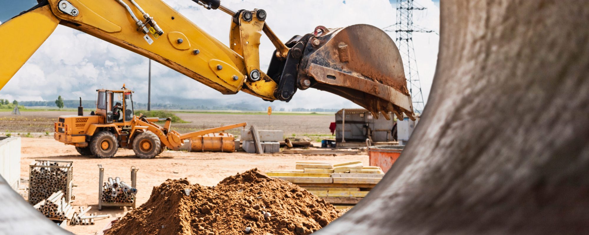 Excavator digs piles. Earthworks for the construction of the foundation. Construction equipment for the device of piles. Preparatory work for grillage. View from a large concrete pipe